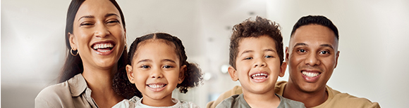 A family of four smiling and laughing