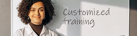 a woman standing next to a white board with the words customized training on it