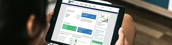 Decorative. Over-the-shoulder view of a man holding a computer tablet with the myVRS website on the screen.