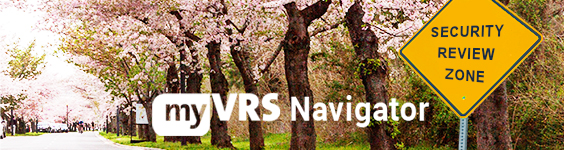 A traffic sign on the right saying security review zone on a road lined with blooming cherry trees. The My VRS Navigator logo is superimposed over the image.