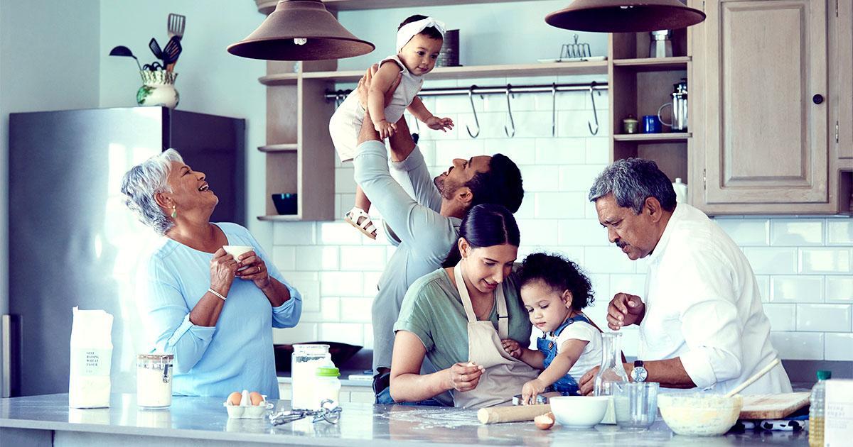 Decorative. A multigenerational family cooks in a large, modern kitchen together.