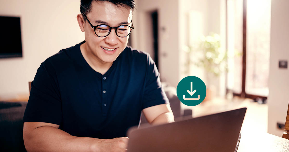 Decorative. A man wearing eyeglasses and a short-sleeved shirt is on the left. He sits at a desk with a laptop computer. A download icon is superimposed above the laptop. To his left is a window.