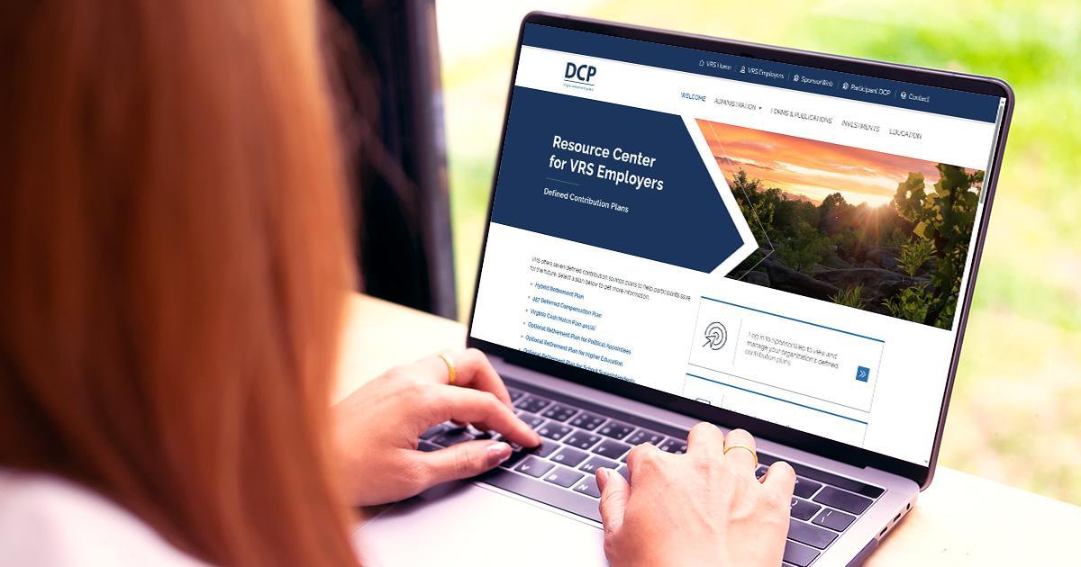 Decorative. An over-the-shoulder view of a young woman typing on a laprop computer. On the screen is the Voya Sponsorweb website. In front of the woman's laptop is a large window with a view of short vegetation.