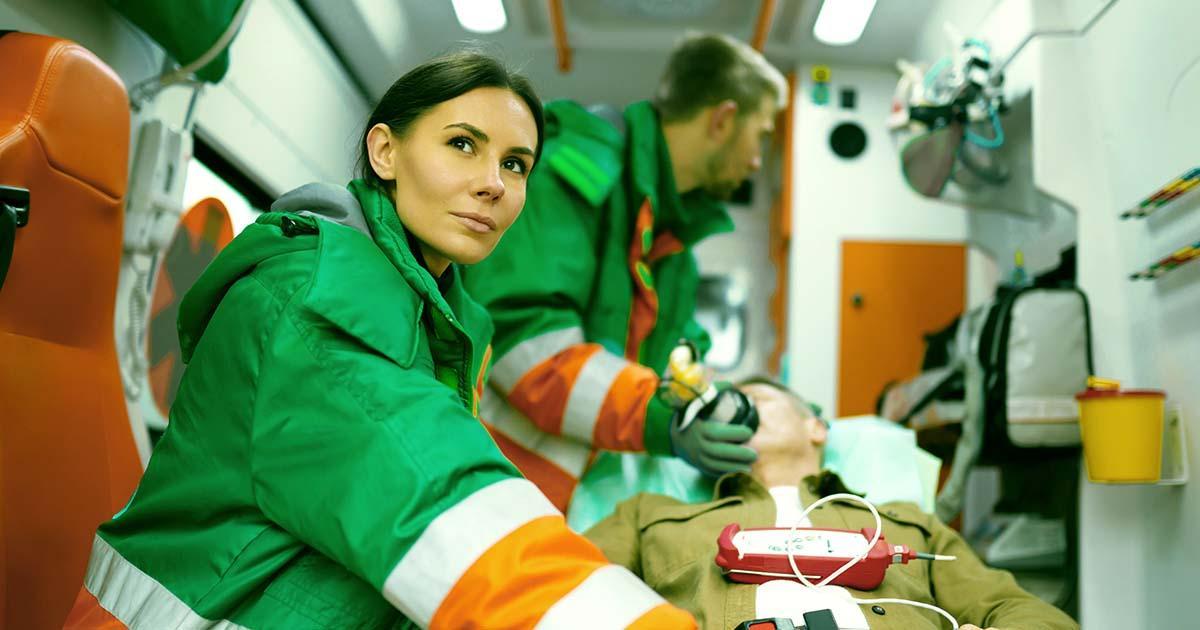 Decorative. A female and a male paramedic load a patient into an ambulance.