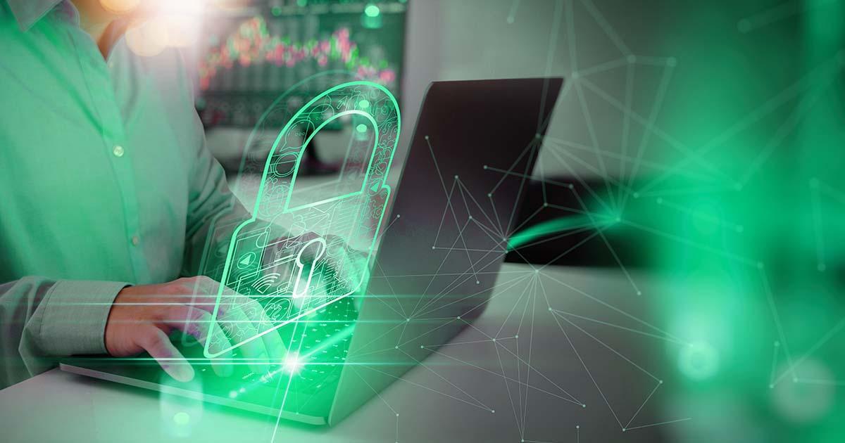 Decorative. Chest and hands of a man weraing a long-sleeved dress shirt, typing on a laptop computer resting on a table. Superimposed over that is a line drawing of a padlock indicating online security.