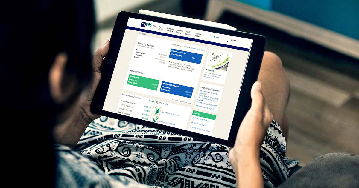 Decorative. Over-the-shoulder view of a woman holding a computer tablet showing a member benefit profile on the screen.