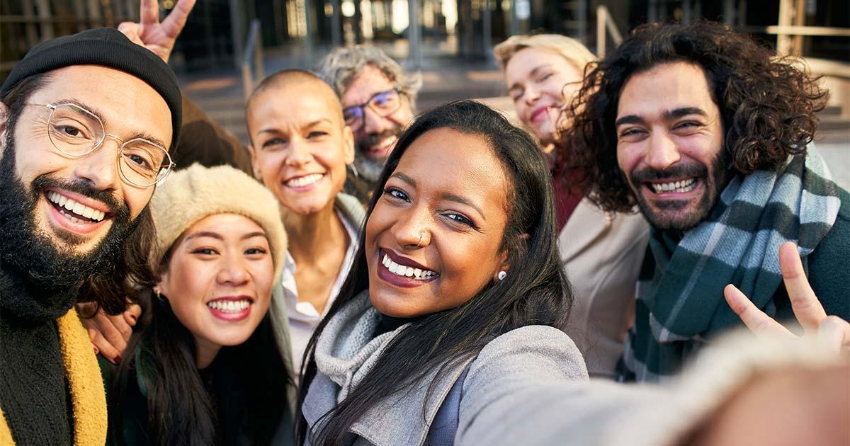 Illustrative. A smiling group of young professionals taking a group photo outdoors.