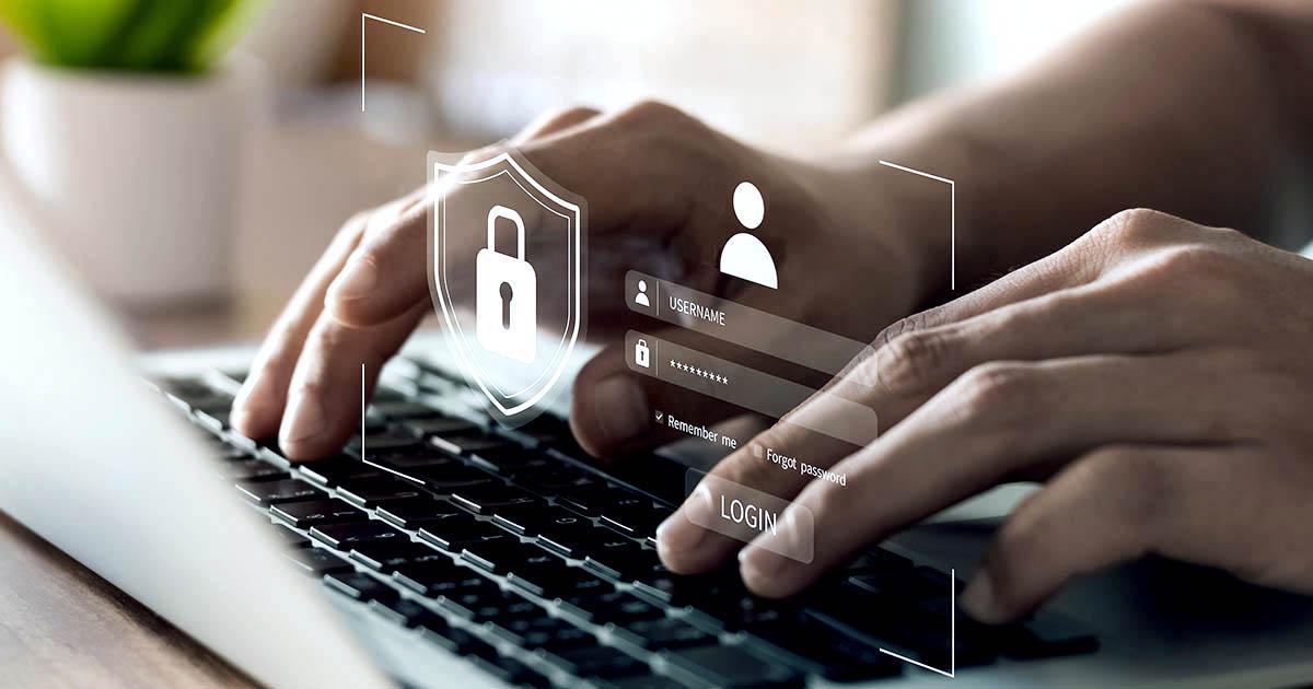 A photo of hands on a laptop computer over which is superimposed a graphic of a padlock, an icon of a person's head and shoulders and login fields for username and password.