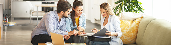 a couple and a counselor look at the counselor's laptop screen together