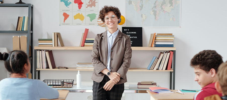 Teacher standing in classroom filled with students.