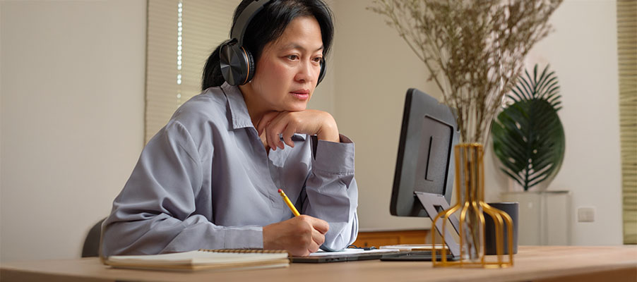 A person wearing headphones and holding a pencil